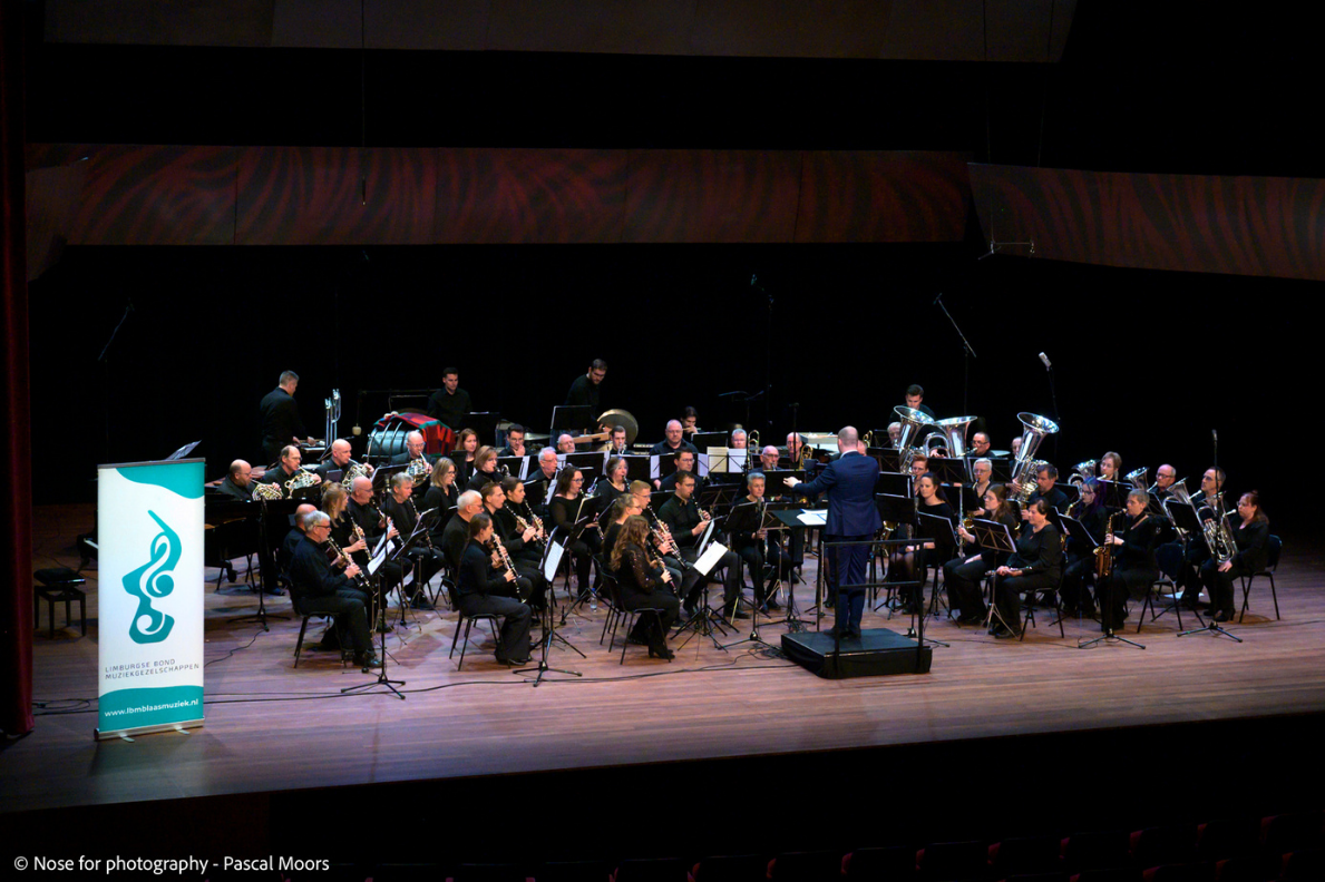 Een blaasorkest op een theaterpodium.