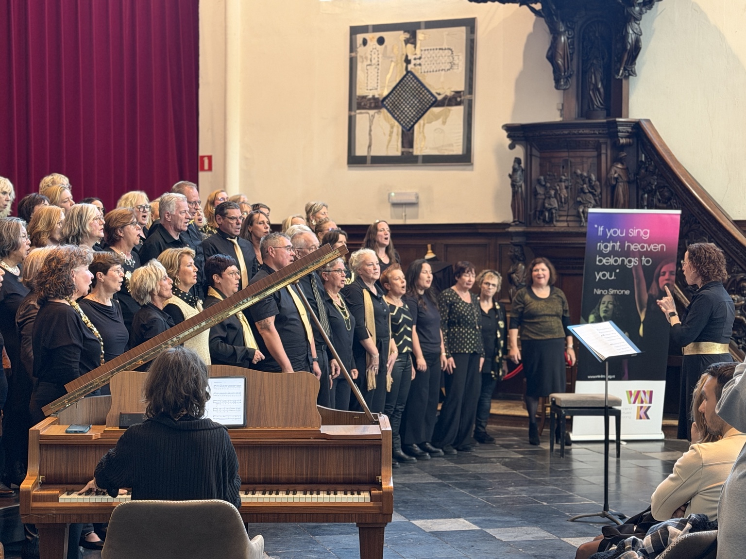 Een koor treedt met pianobegeleiding op in de Paterskerk.